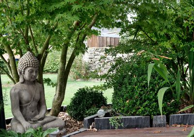 bouddha dans un massif de plantations