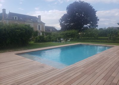 Belle terrasse en bois exotique autour d'une piscine à proximité d'une maison bourgeoise